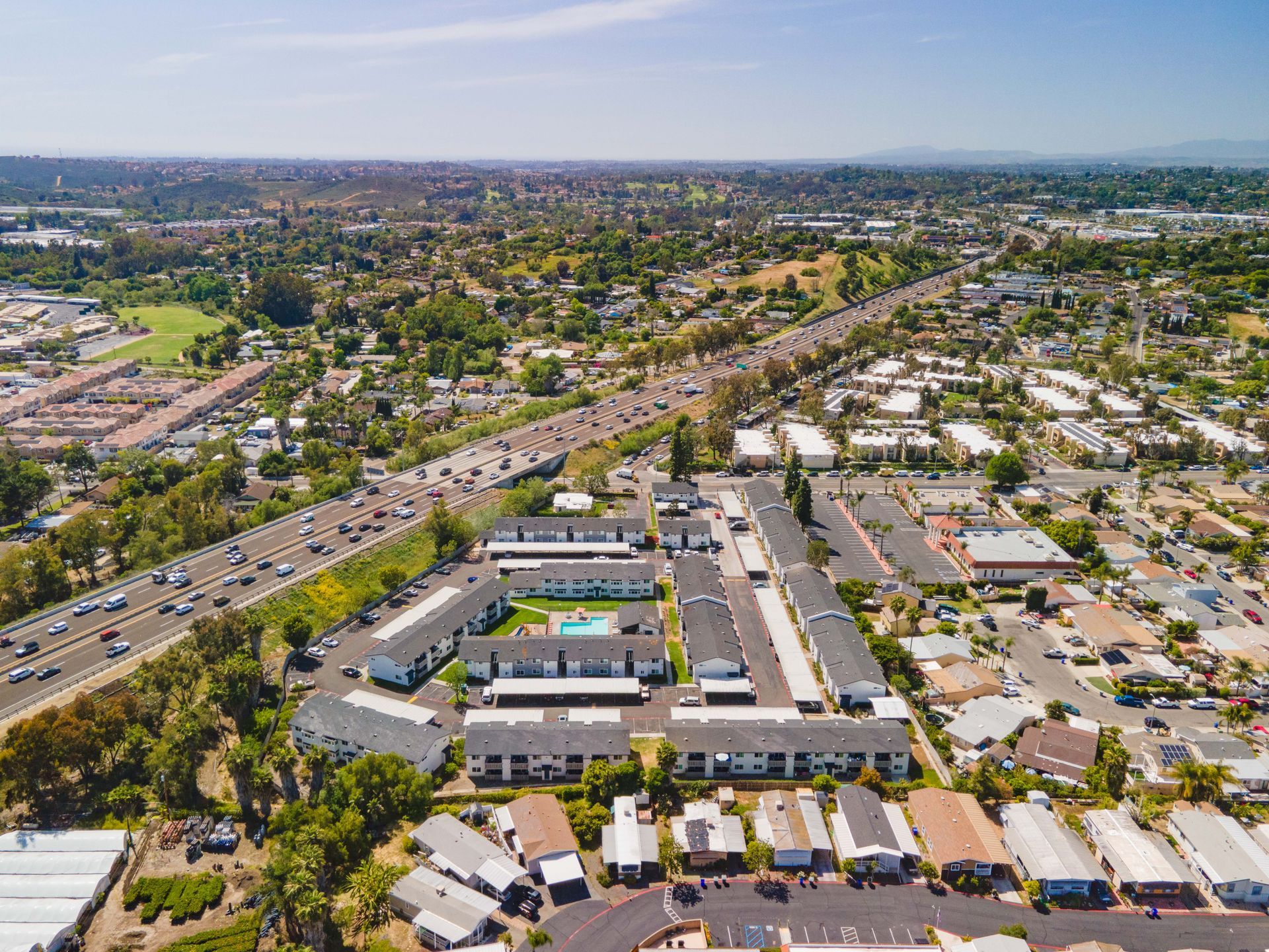 Aerial view of a suburban neighborhood with homes, streets, and a central pool complex.