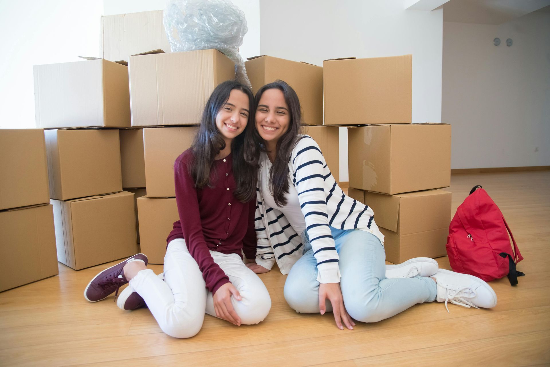 Students sitting in dorm room with boxes
