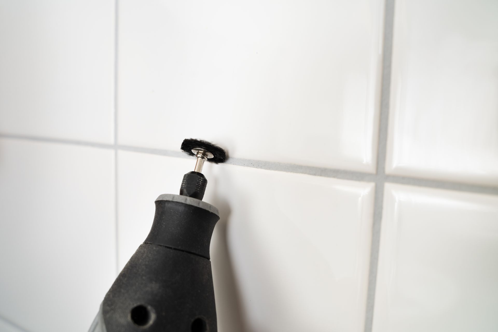 White rectangular subway tiles on two walls meeting at a corner with dark grout lines.