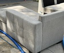 Gray concrete bench or planter corner beside a blue hose on pavement.