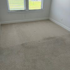 Empty beige bedroom with carpet, white walls, and a window with blinds.
