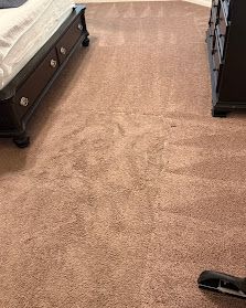 Carpeted hallway with dark wood furniture along the sides and a small black object on the floor