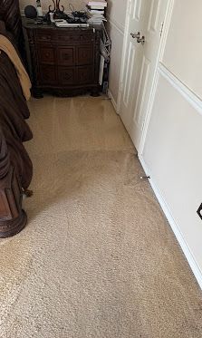 Carpeted hallway with white walls and a dark wooden cabinet at the far end.