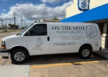 White On the Spot Floor Care van parked outside a store under a blue awning.