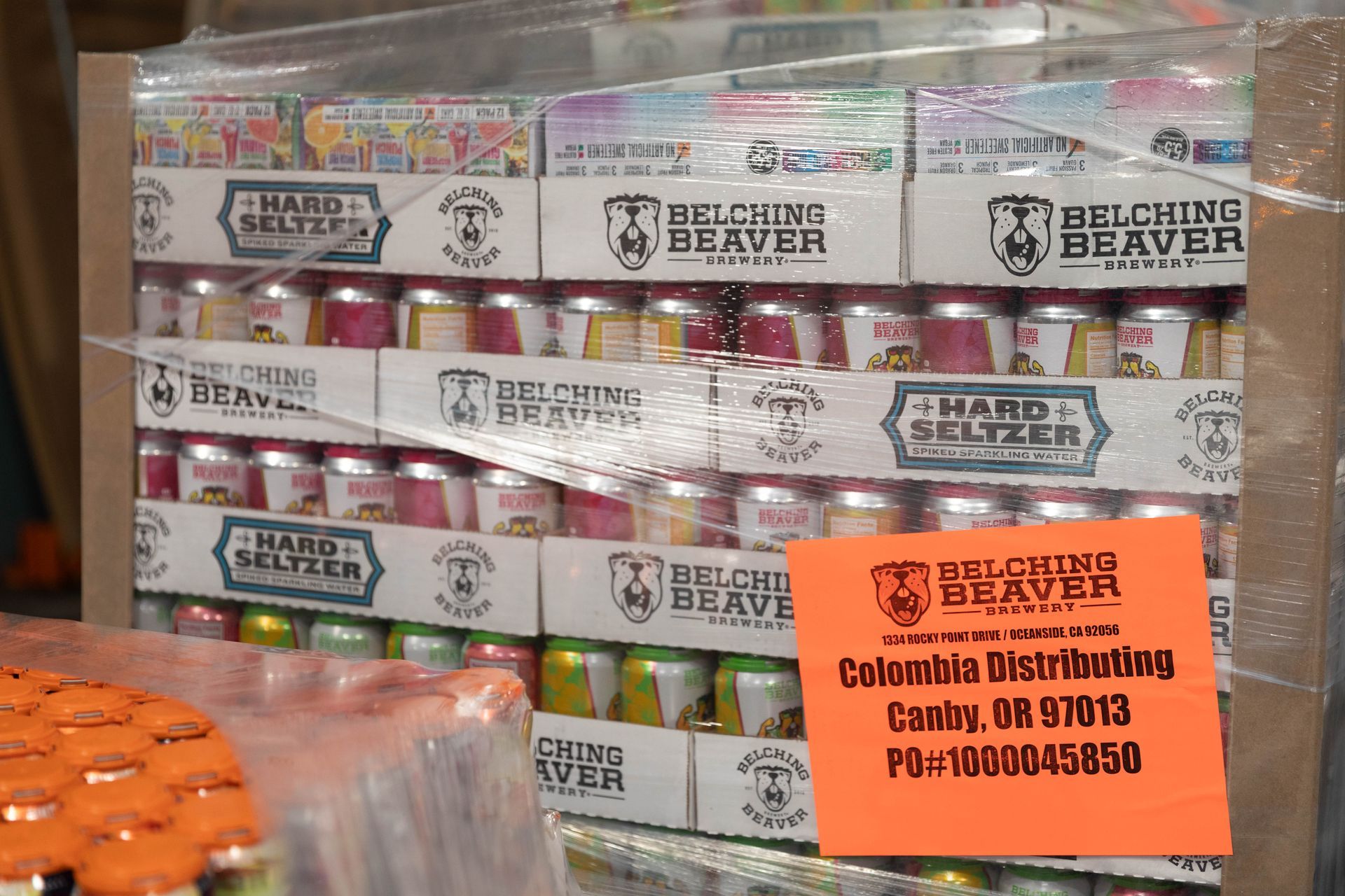 three cans of seaborn cocktails are sitting on a conveyor belt .