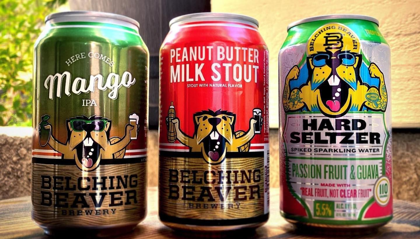 three cans of beer are sitting on a table .