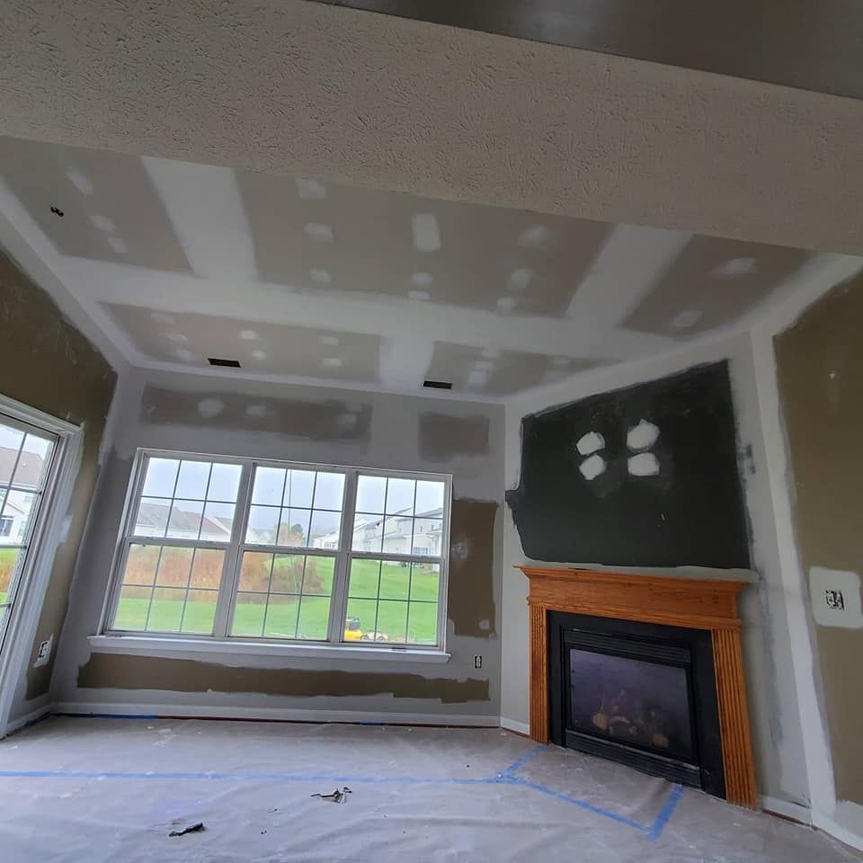 A living room with a fireplace and a lot of windows.