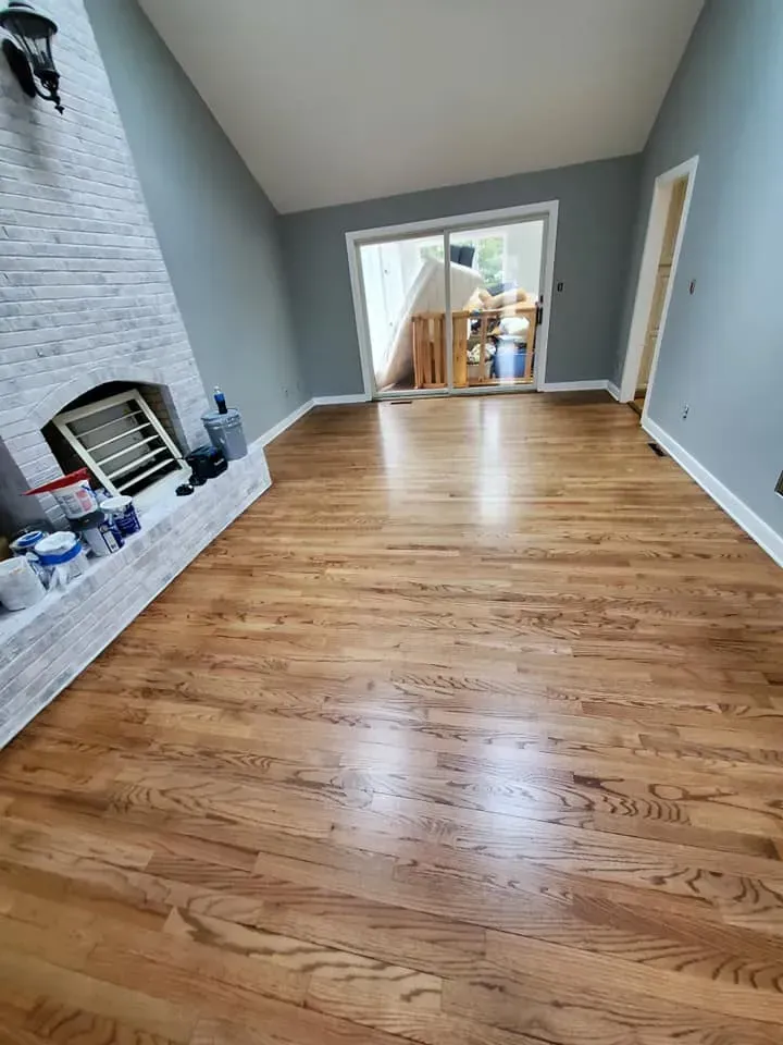 A living room with hardwood floors and a fireplace.