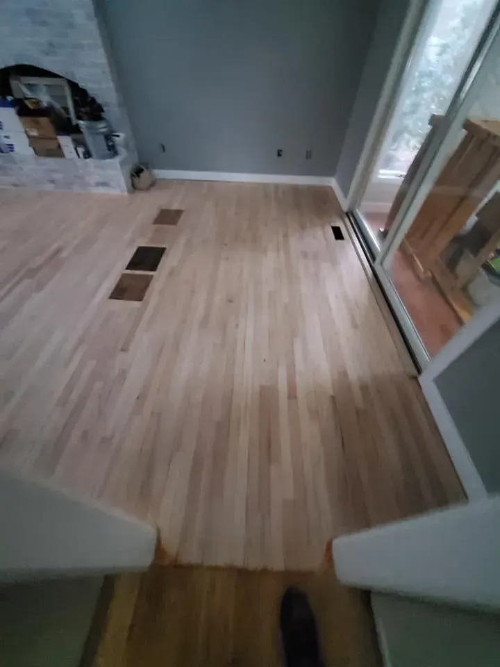 A living room with hardwood floors and a fireplace.