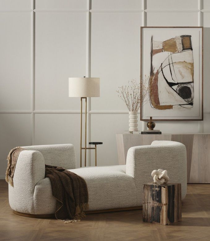 A living room with a chaise lounge and a painting on the wall