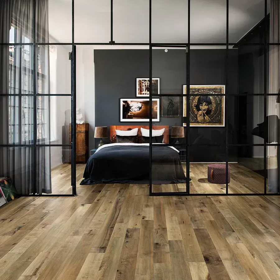 A bedroom with hardwood floors and a sliding glass door