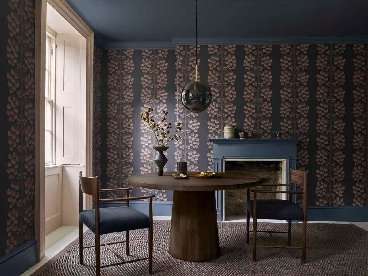 A dining room with a round table and chairs and a fireplace.