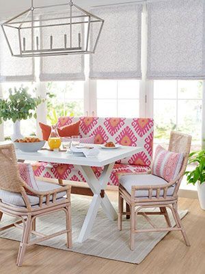 A dining room with a table and chairs and a couch.