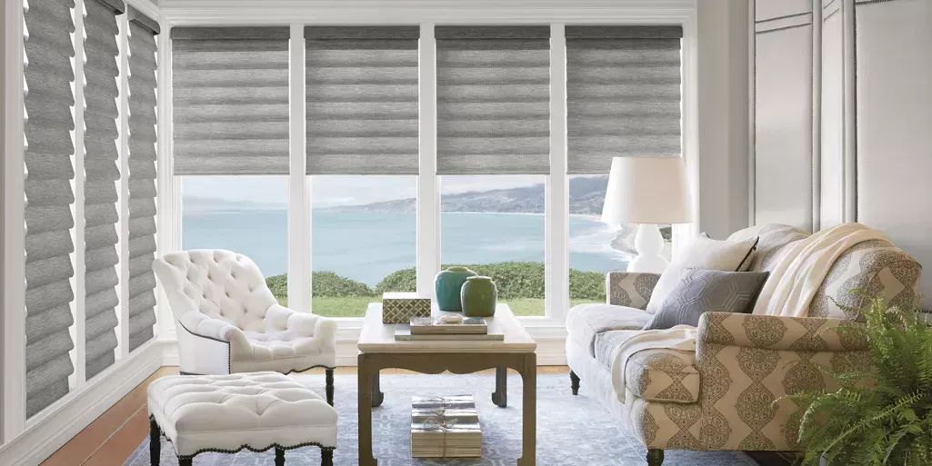 A living room with a couch , chair , coffee table and sliding glass doors.