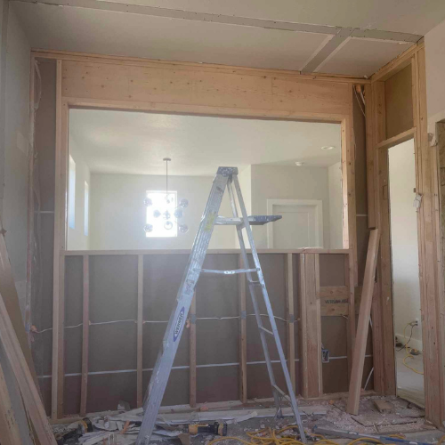 Interior construction: Wooden frame with a window opening, ladder inside.