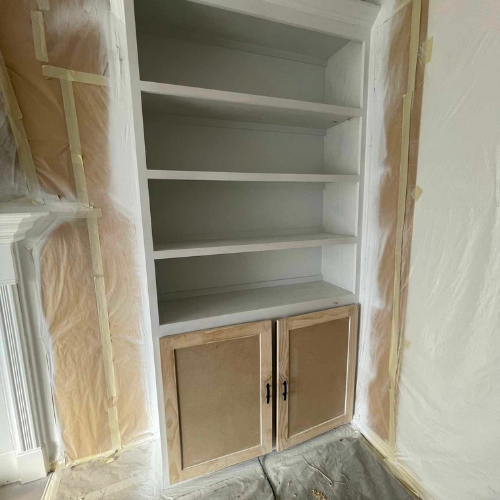 White bookshelf with natural wood cabinet doors, partially painted.