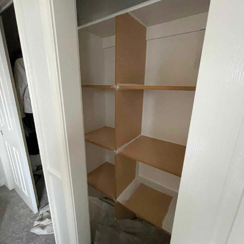 White closet interior with brown shelves and support beams.