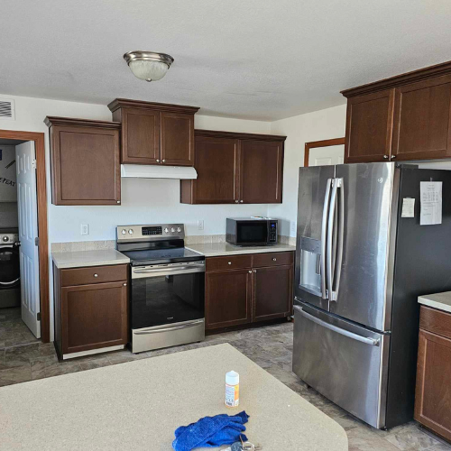Kitchen with brown cabinets, stainless steel appliances, and a light-colored countertop.