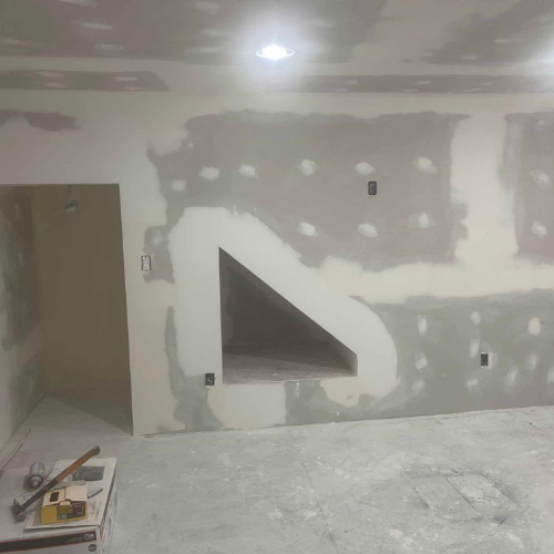 Room under construction with drywall and an angled wall niche.