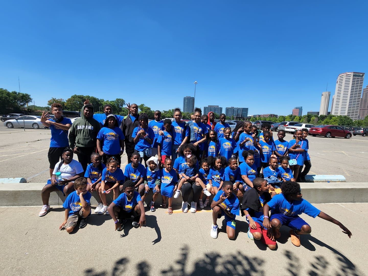 A group of children are posing for a picture in a parking lot.