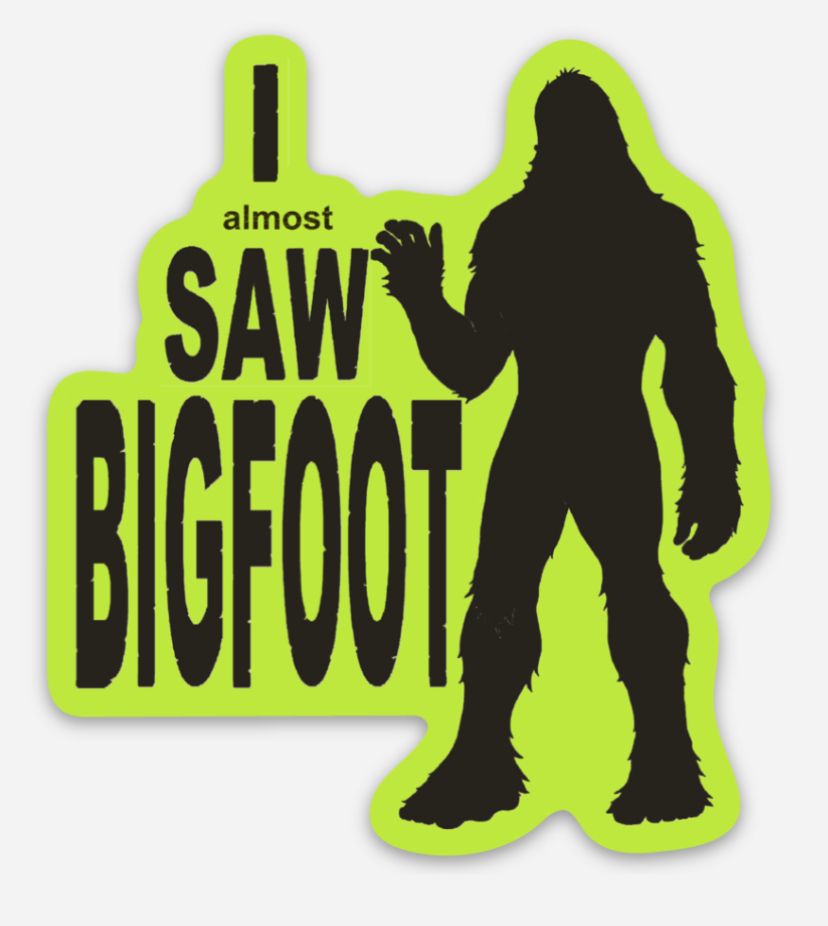 Neon green sign with black silhouette of Bigfoot and text “I almost SAW BIGFOOT”