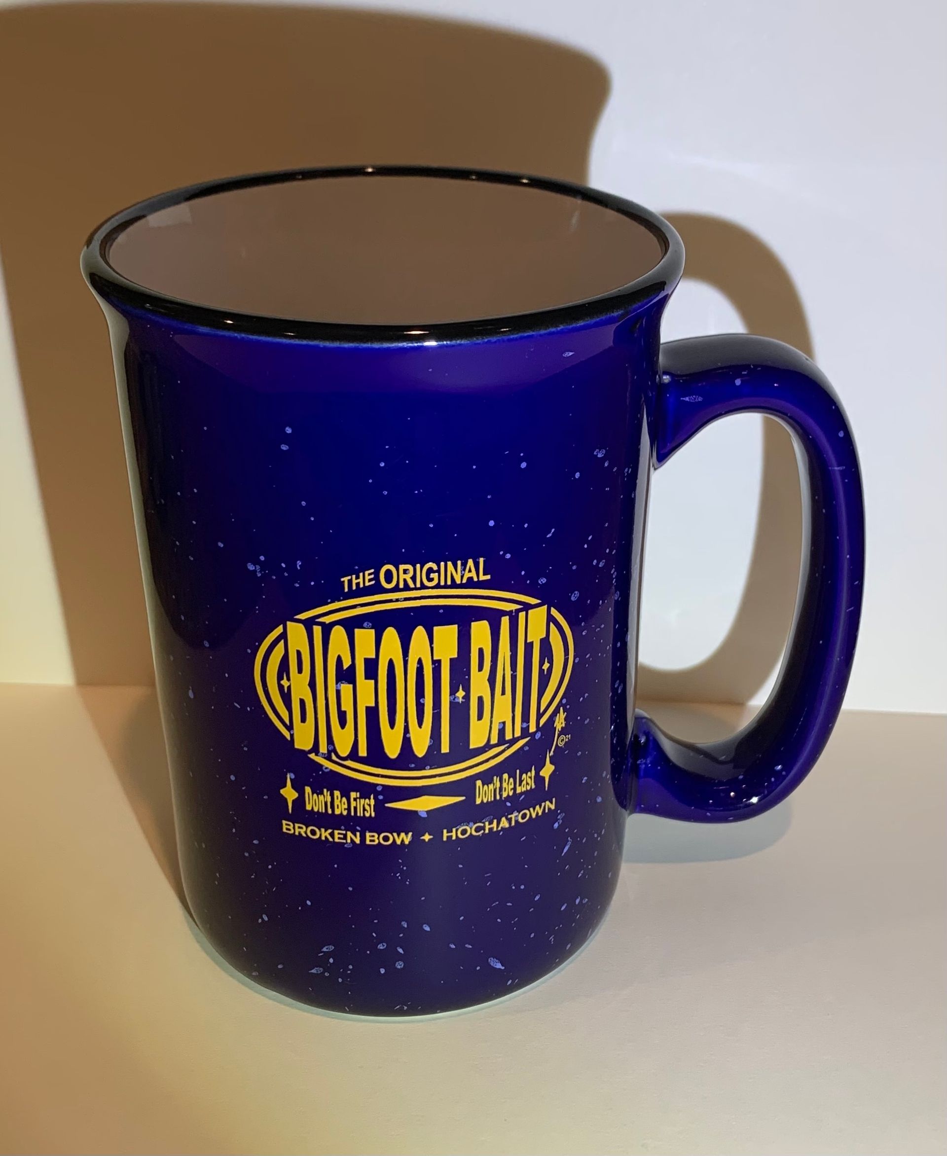 Blue speckled mug with Bigfoot Trail logo on a tabletop