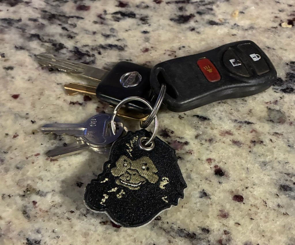 Keys with black car fob and keychain on a speckled countertop