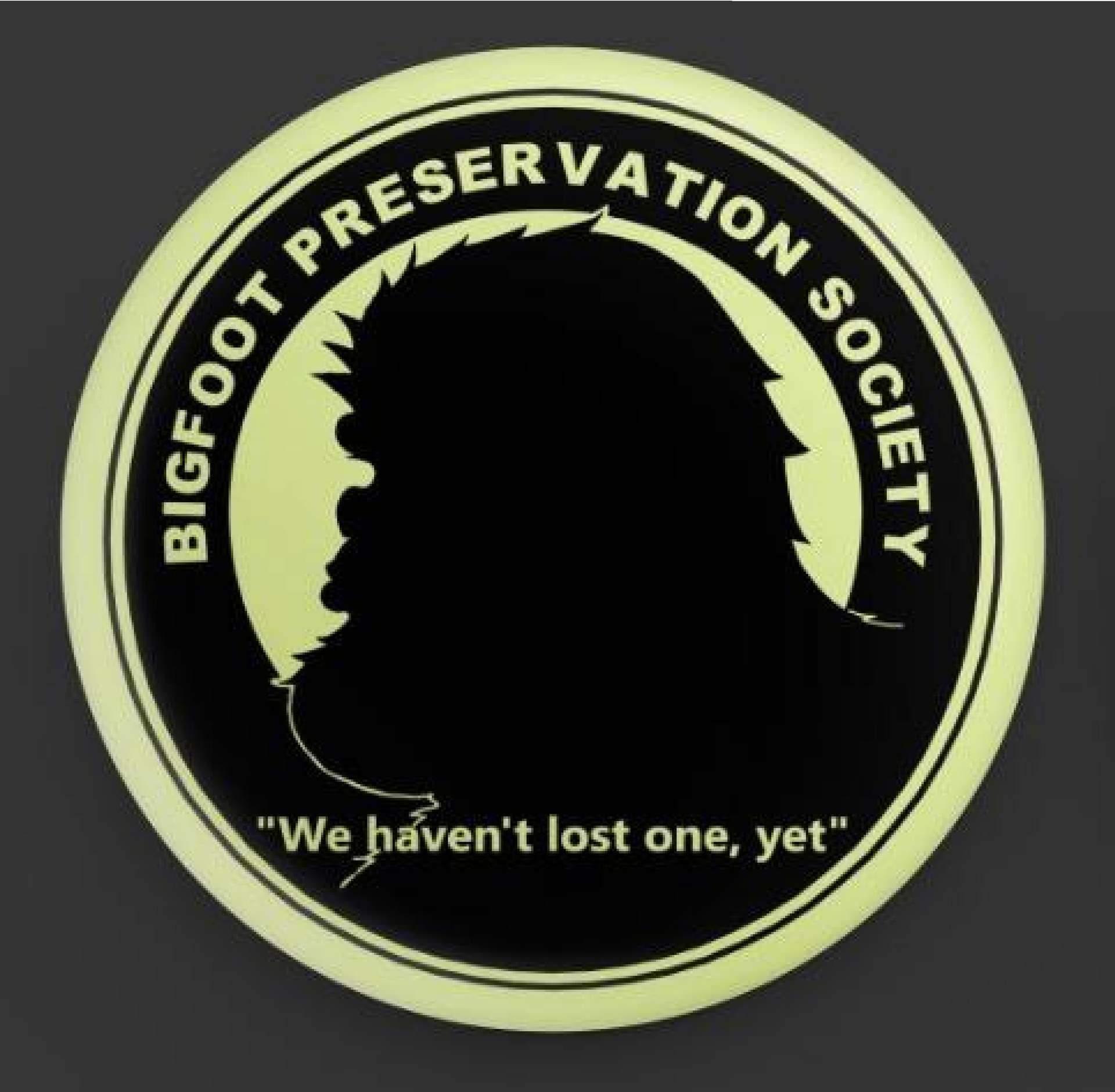 Bigfoot Preservation Society logo in pale green and black with the slogan “We haven’t lost one, yet.”