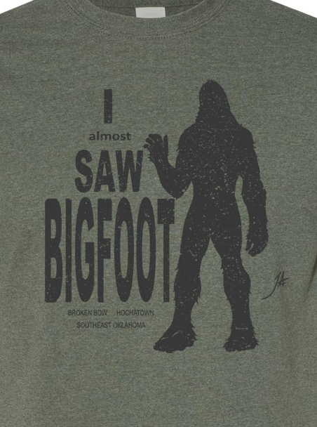 Green T-shirt with a dark Bigfoot graphic and text on the front