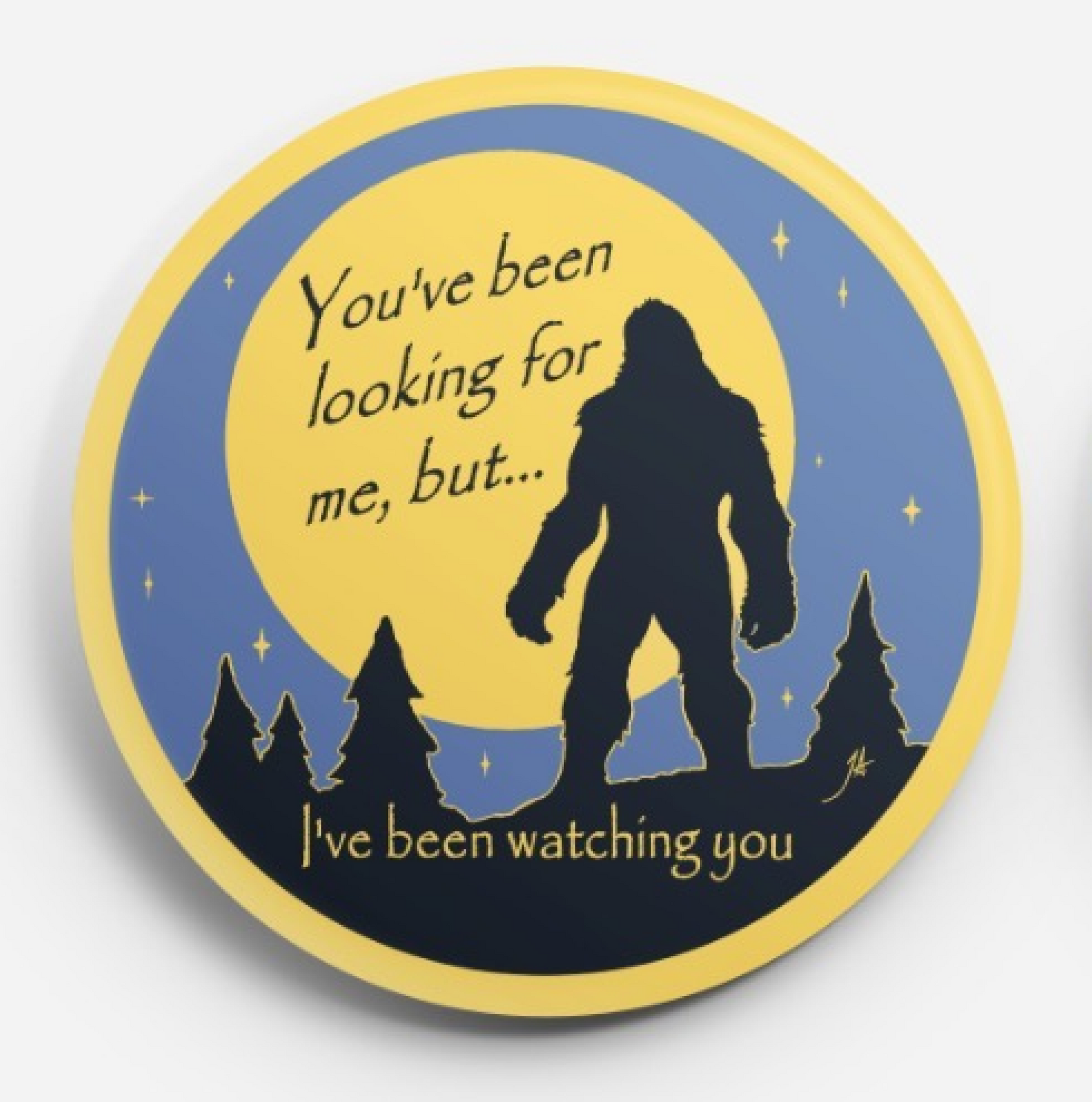Yellow circular badge with Bigfoot silhouette and text, “You’ve been looking for me, but… I’ve been watching you.”