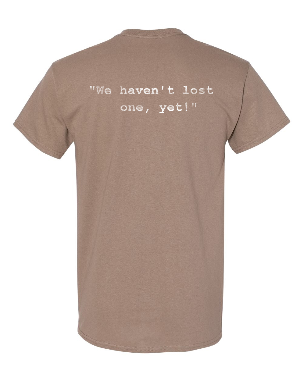 Tan T-shirt with white text reading, “We haven’t lost one, yet!”