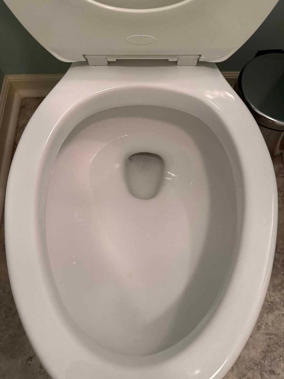 White toilet bowl with water and lid up.