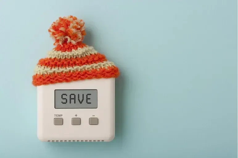 a thermostat with a knitted hat on top of it .