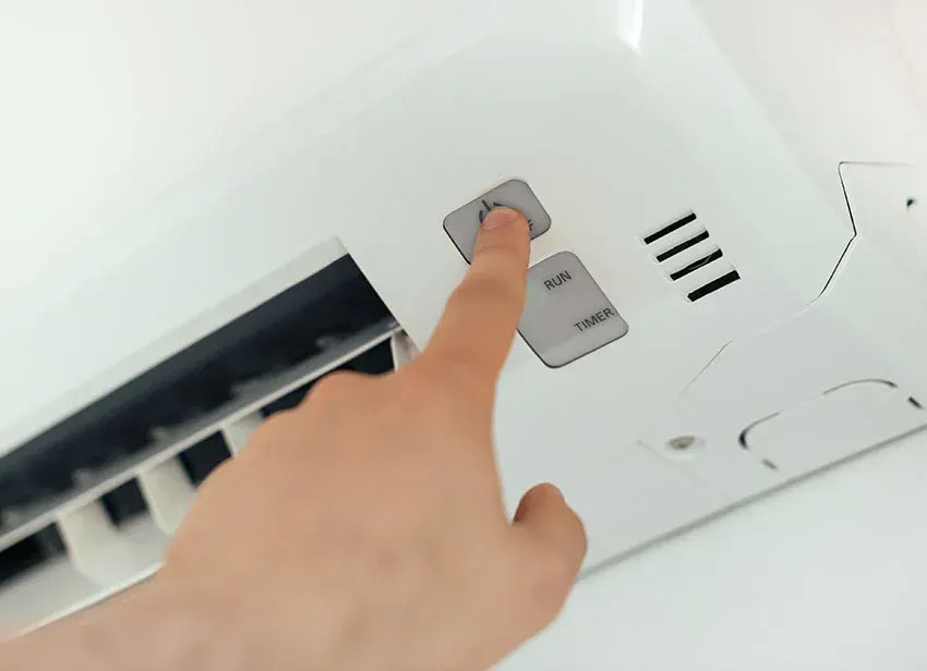 hand turns on air conditioning