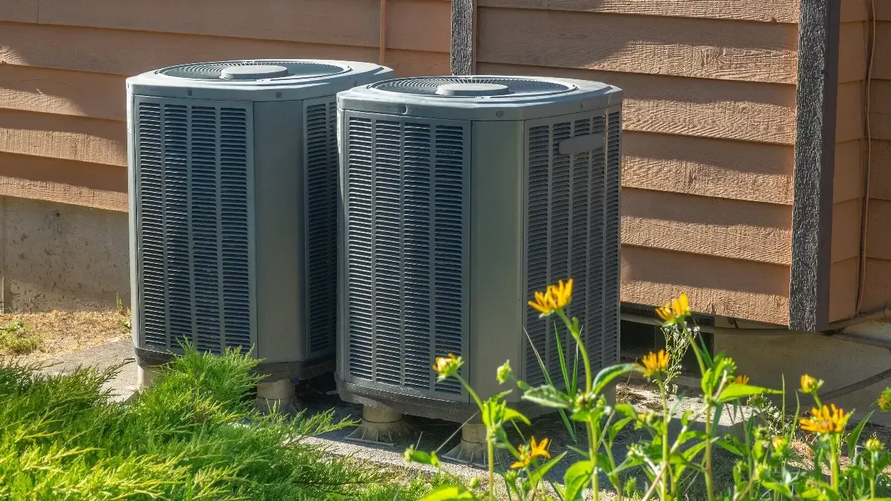 Photo of 2 side by side central air conditioning units outside of home