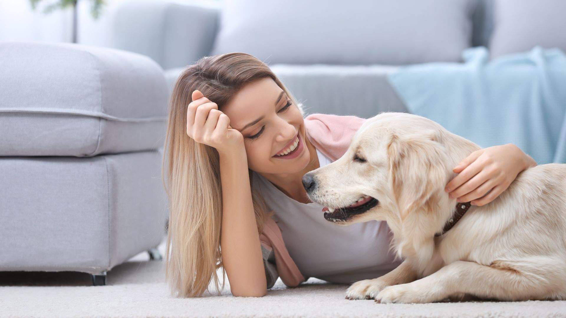 a woman and her dog laying on a rug