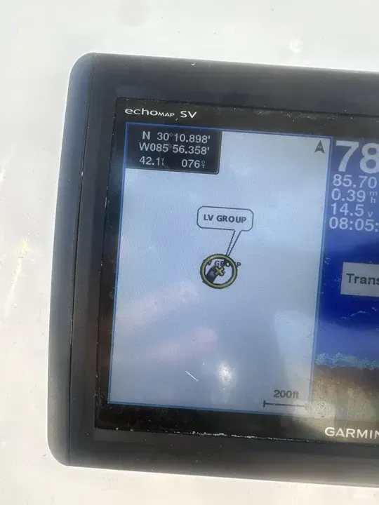 Garmin GPS screen with map, route marker, and speed readout on a boat dashboard