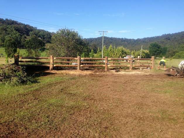 A Wooden Fence is in the Middle of a Grassy Field — SMH Valley Fencing & Maintenance In Lochinvar, NSW
