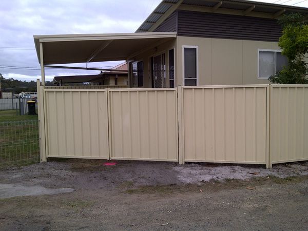 A House With a Fence in Front of It — SMH Valley Fencing & Maintenance In Lochinvar, NSW
