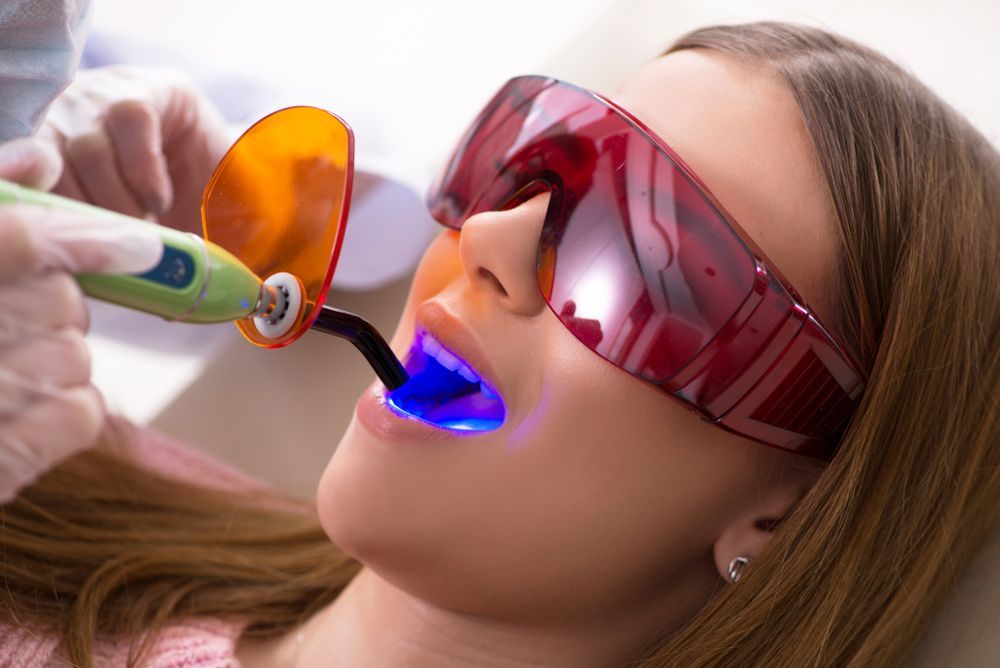 A Woman Is Getting Her Teeth Whitened By A Dentist — Regal's Dental In Yeppoon, QLD