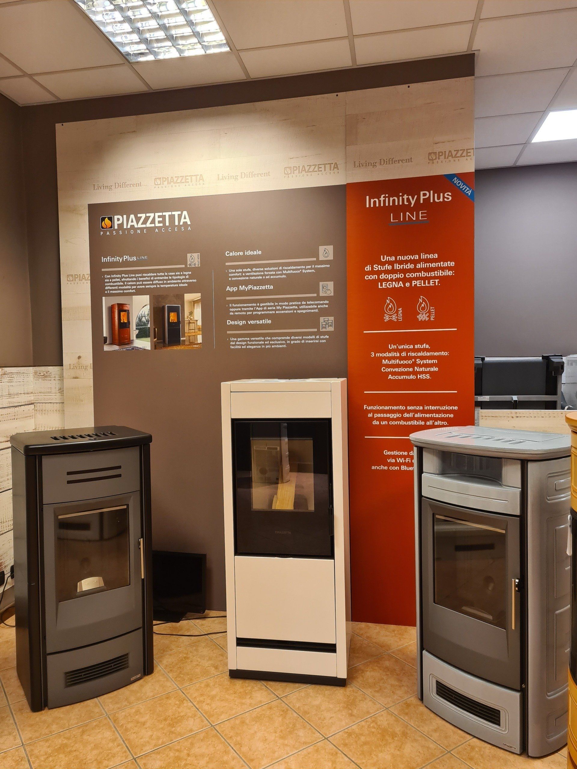 Area espositiva con tre fornelli/forni e pannelli informativi sui prodotti in uno showroom.