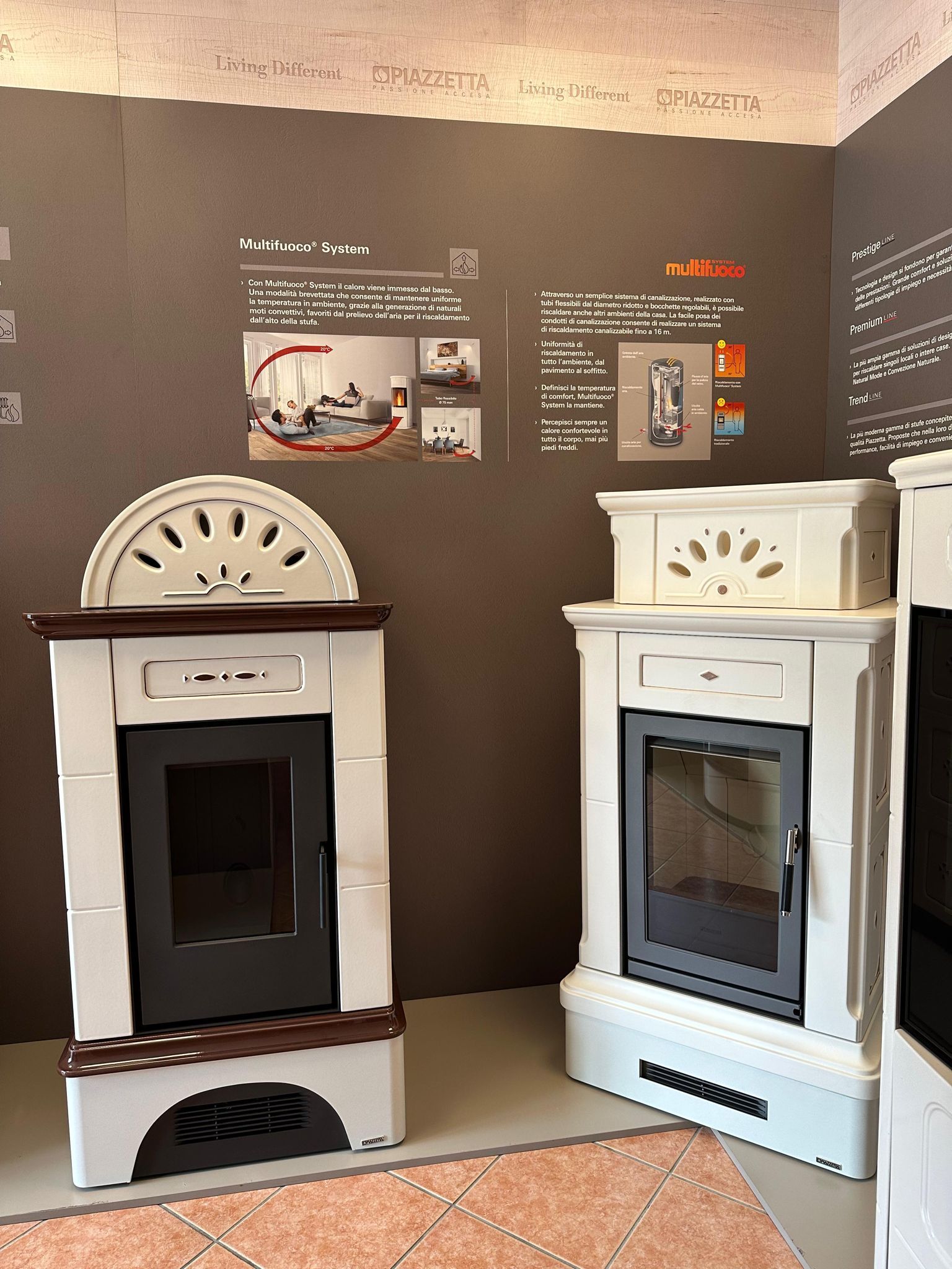 Due stufe decorative bianche esposte in una mostra museale contro una parete scura con pannelli informativi