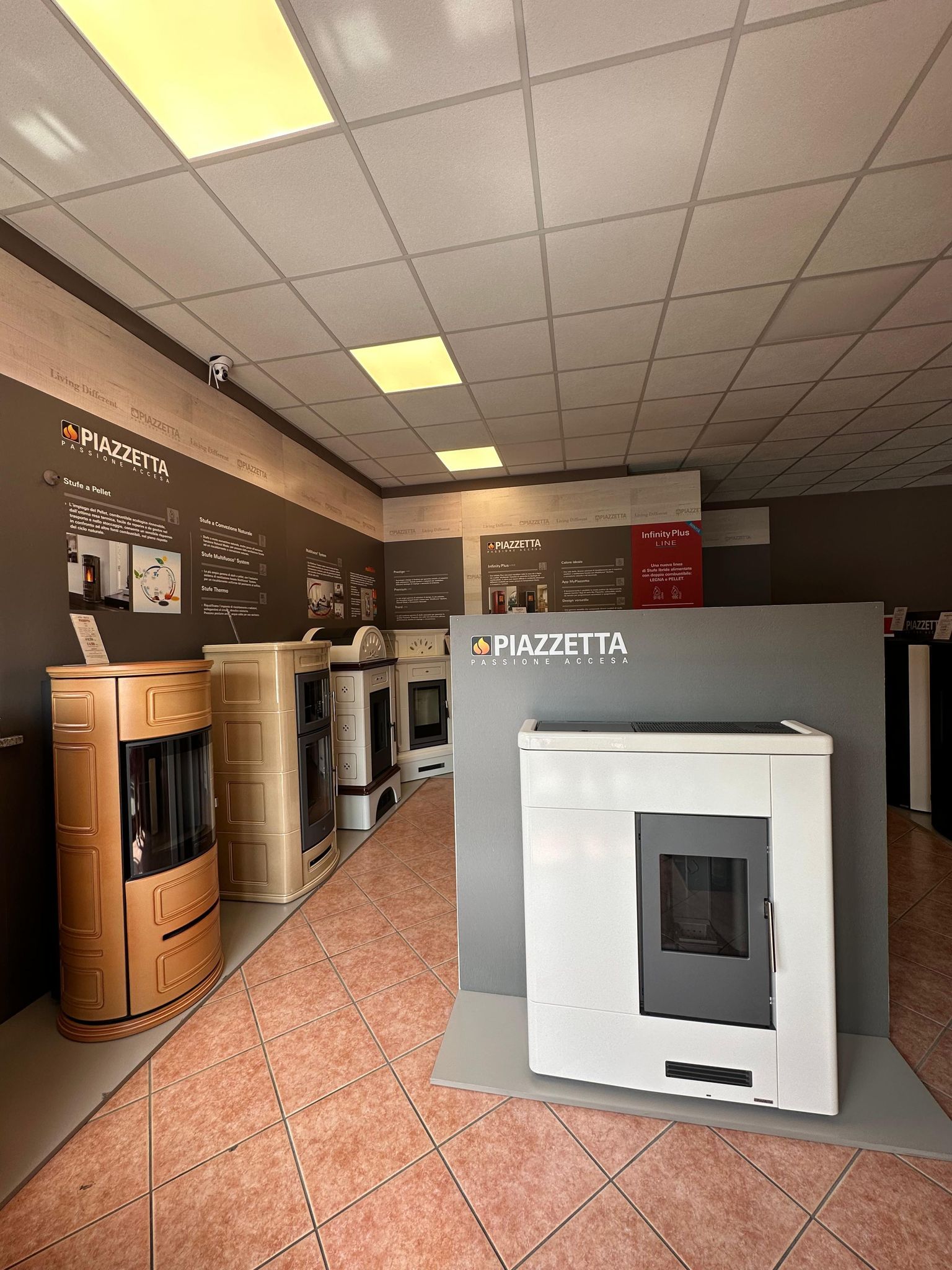 Showroom di elettrodomestici con esposizione di forni bianchi e in acciaio inossidabile sotto luminose luci a soffitto.