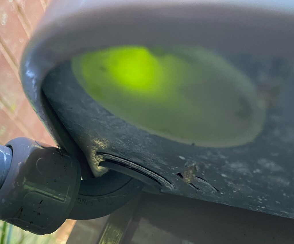 Close-up of a gray chair seat with a bright lime-green spot and a black wheel mount underneath