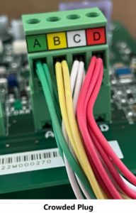 Crowded multicolor wires plugged into a green circuit board connector labeled A, B, C, D