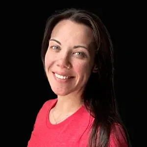 Smiling woman in a bright pink shirt against a black background