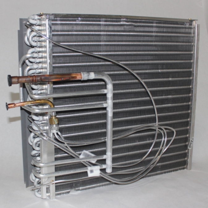 Metal HVAC evaporator coil with copper tubing and gray fins on a white background