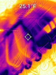 Thermal view of a hand holding a tool or device, with a 25.1°F temperature reading.
