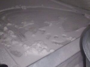 Snow-covered ground with scattered footprints and a partial car tire on the right