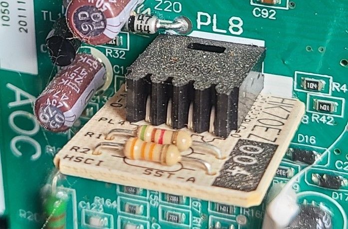 Close-up of a circuit board with a small black heatsink and beige component module.
